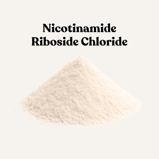 A small pile of fine off-white powder labeled 'Nicotinamide Riboside Chloride' on a light beige background, with three icon badges below reading Vegan, Sustainably Farmed, and Cruelty Free.